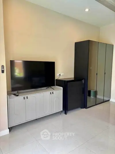 Modern living room with sleek TV stand and mirrored wardrobe, perfect for stylish urban living.