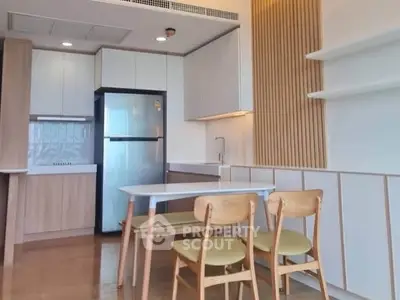 Modern kitchen with sleek design, featuring a dining area and contemporary appliances.