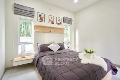 Cozy bedroom with modern decor, featuring a plush bed, stylish artwork, and natural light from large windows.