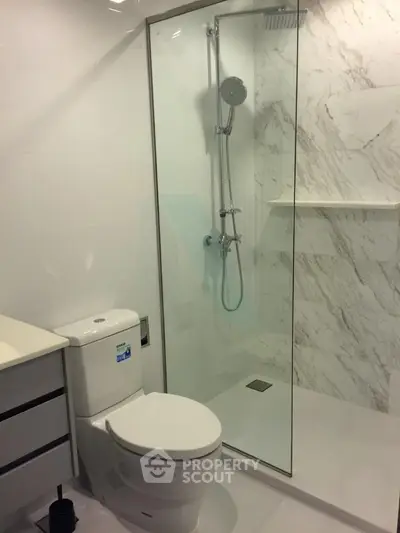 Modern bathroom with glass shower and sleek fixtures in a contemporary apartment.