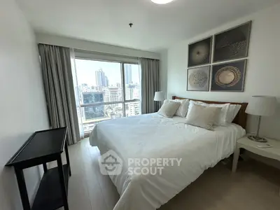 Modern bedroom with city view, featuring a cozy bed and elegant decor in a high-rise apartment.