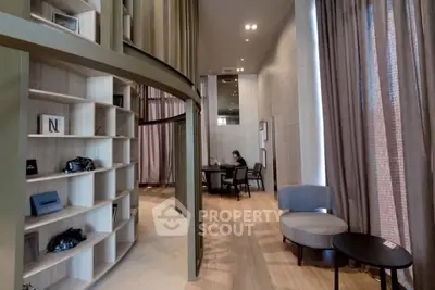 Modern interior with high ceilings, elegant decor, and cozy seating area in a stylish apartment.