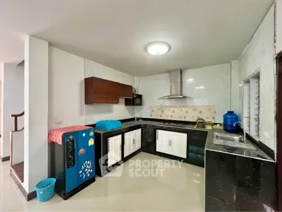 Modern kitchen with sleek black countertops and stylish cabinetry in a spacious home.