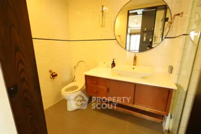 Modern bathroom with stylish vanity and round mirror in a contemporary home.