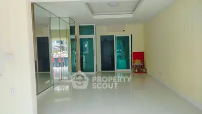 Spacious empty room with mirrored wall and glossy white tiles