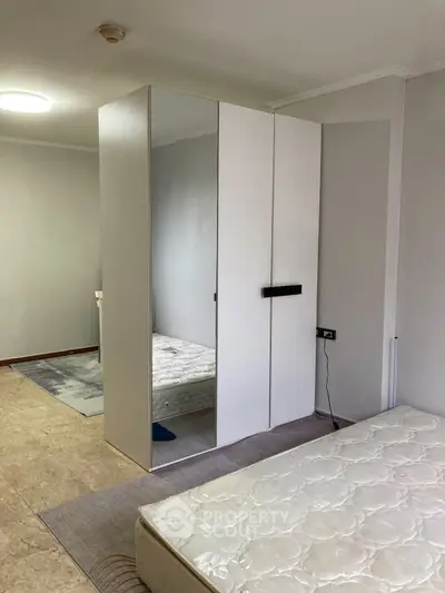 Spacious bedroom with mirrored wardrobe and minimalist decor