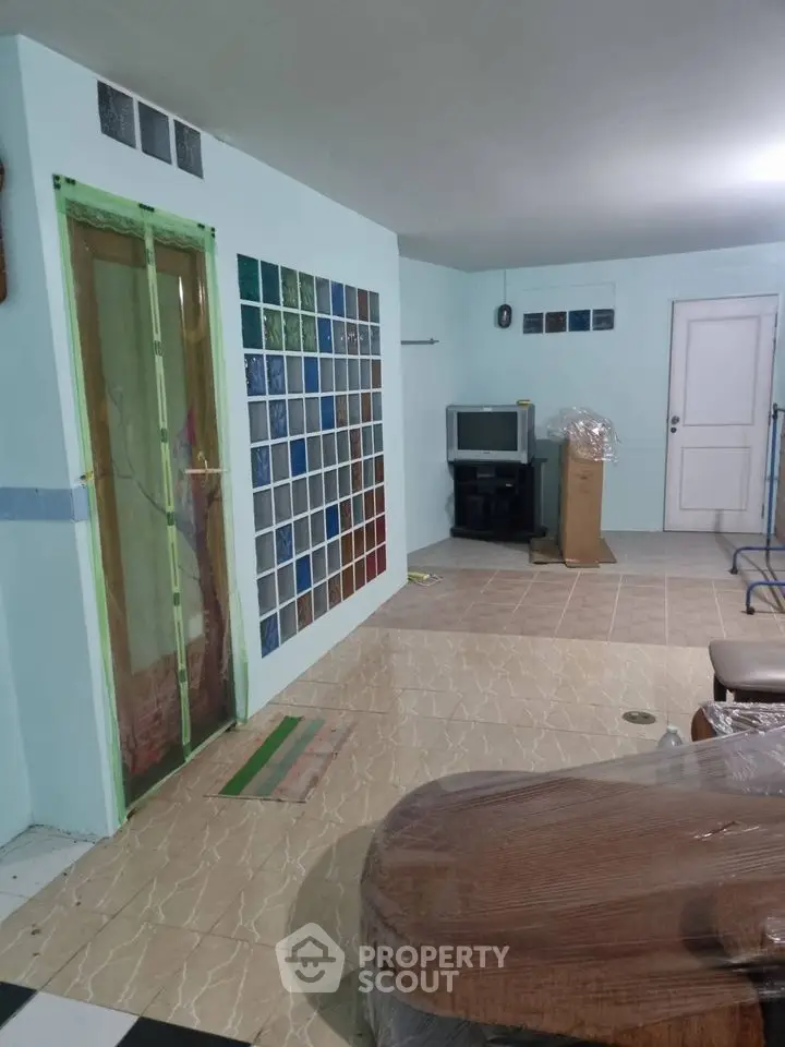 Spacious living room with tiled floor and colorful glass wall accents