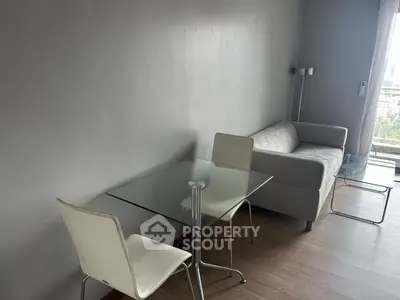 Modern living room with sleek glass table and cozy sofa, perfect for urban living.