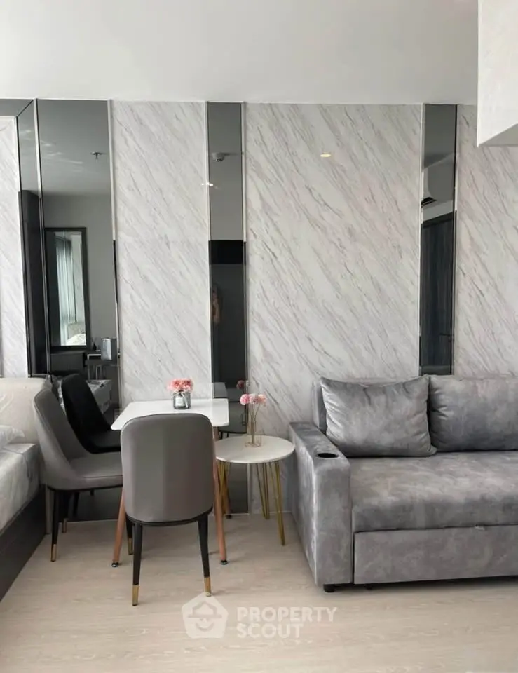 Modern living room with stylish gray sofa and chic dining area in contemporary apartment.