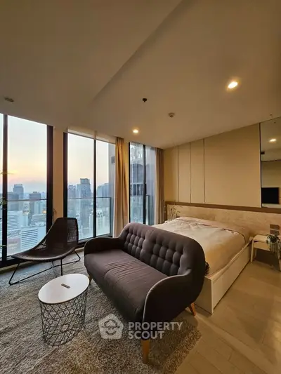 Luxurious bedroom with stunning city view and modern furnishings in high-rise apartment.