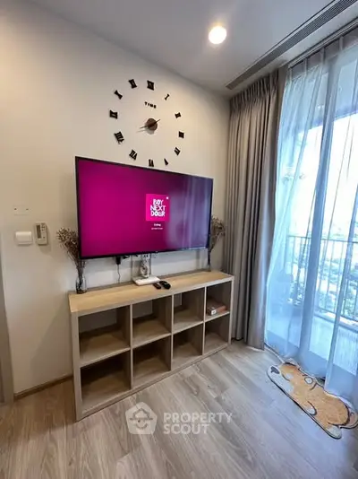 Modern living room with wall-mounted TV and stylish decor, featuring a large window with balcony view.