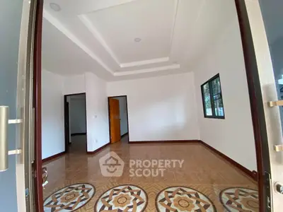 Spacious unfurnished room with decorative tiled floor and large windows in modern home.