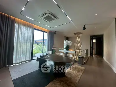 Luxurious modern living room with elegant dining area and large windows offering a serene garden view.