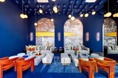 Luxurious living room with vibrant blue walls, elegant lighting, and stylish furniture.