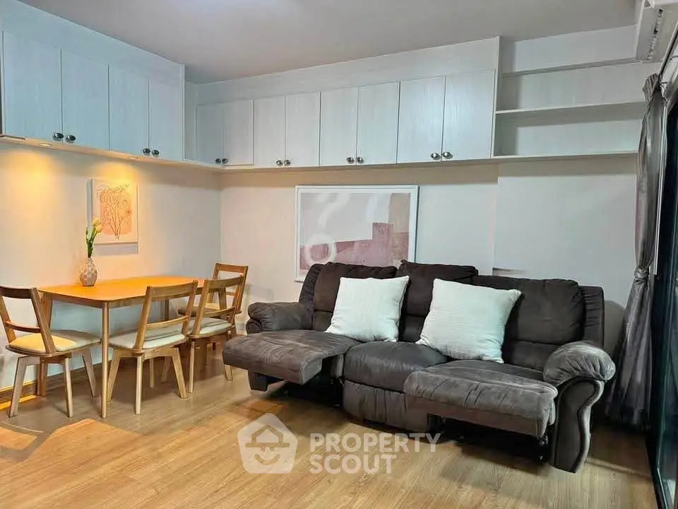 Cozy living room with plush sofa and dining area, featuring modern decor and ample storage.
