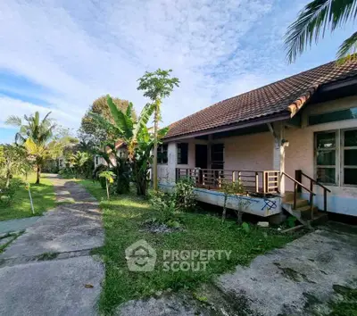 Charming tropical bungalow with lush garden and spacious veranda, perfect for serene living.