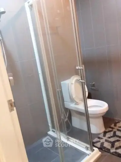 Modern bathroom with glass shower and sleek gray tiles