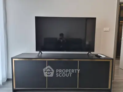 Modern living room with sleek TV stand and large flat-screen TV, perfect for entertainment.