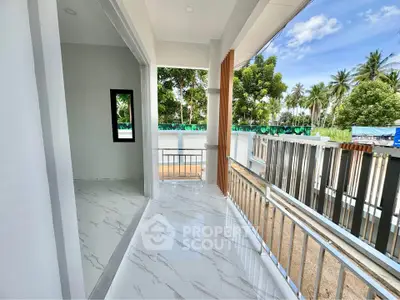 Spacious balcony with modern tiles and lush garden view, perfect for relaxation.