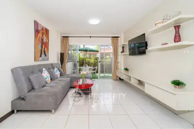 Spacious living room with modern decor and garden view, featuring a stylish sofa and wall-mounted TV.
