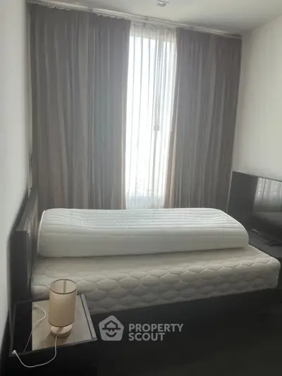 Cozy bedroom with natural light and modern furnishings, perfect for relaxation and comfort.