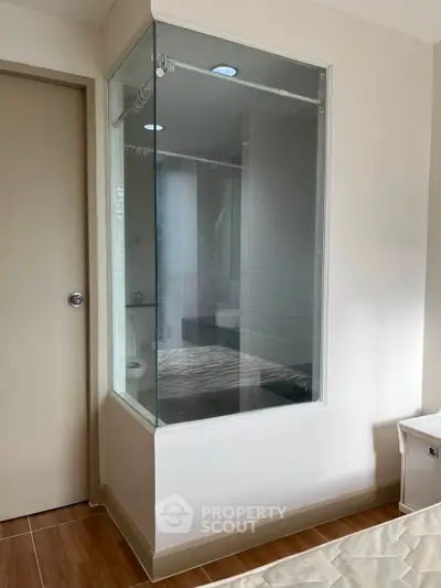 Modern bedroom with unique glass-enclosed shower, blending privacy and style in a contemporary design.
