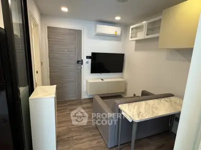 Modern living room with sleek furniture and wall-mounted TV in a cozy apartment.