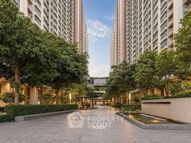 Stunning modern apartment complex with lush greenery and spacious courtyard.