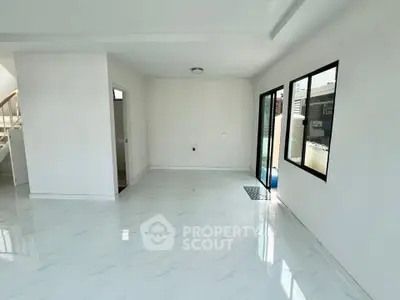 Spacious modern living room with large windows and sleek white flooring