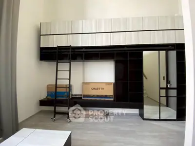 Modern loft-style living room with high ceiling and built-in storage