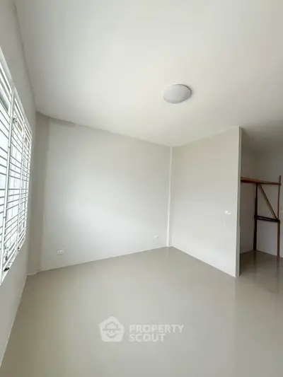 Spacious empty room with large windows and closet space, perfect for customization.