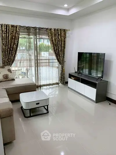 Modern living room with sleek TV setup and elegant curtains