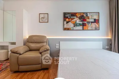Modern bedroom with stylish decor and comfortable seating in a contemporary apartment.