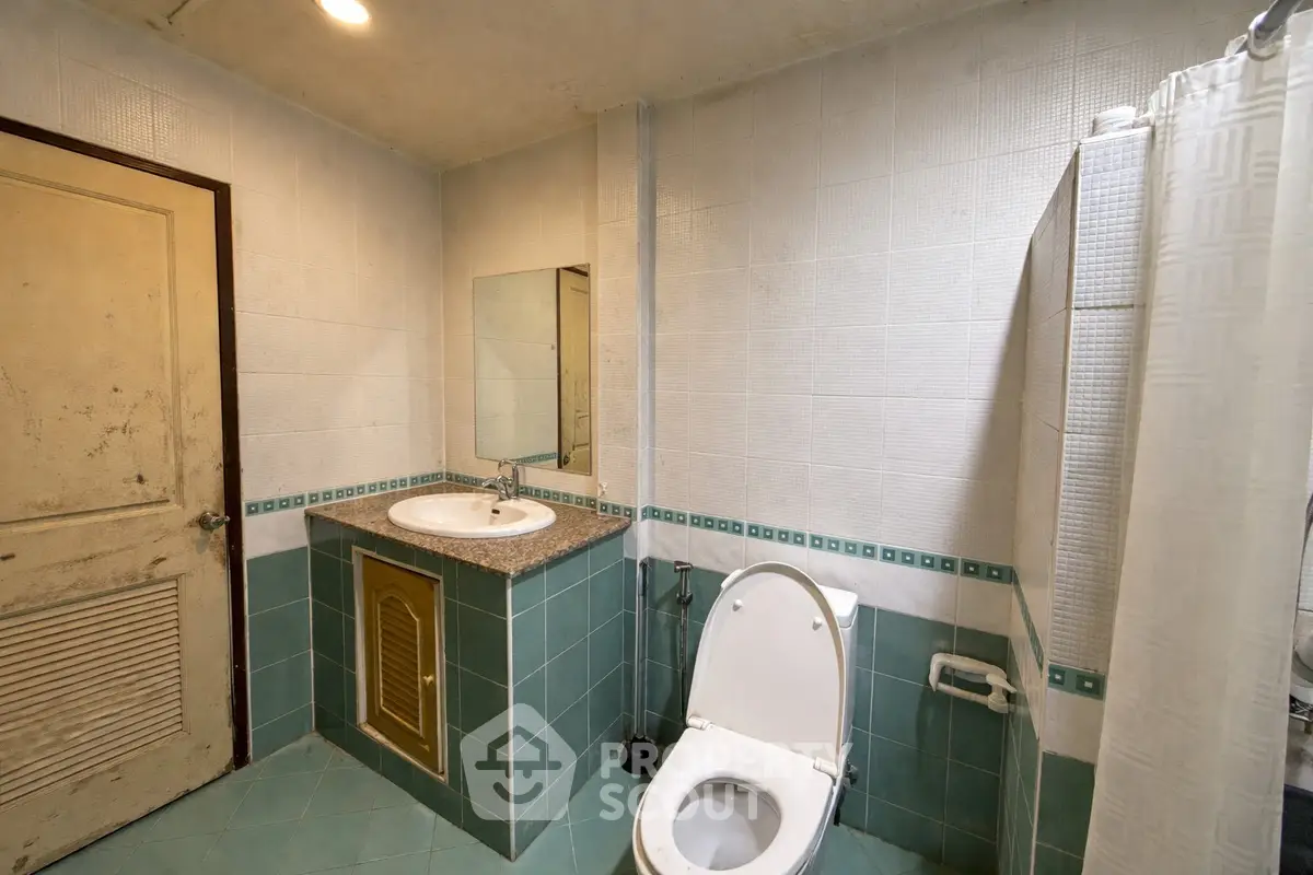 Spacious bathroom with modern fixtures and tiled walls, featuring a shower and toilet.