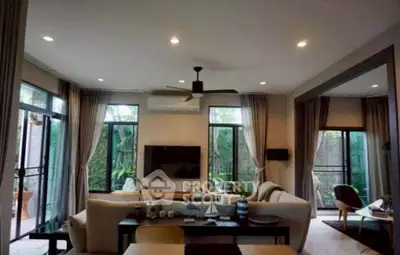 Spacious living room with modern decor and large windows offering garden views.