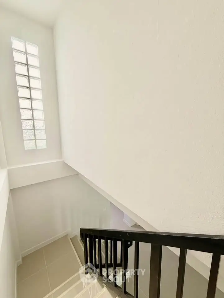 Bright stairwell with modern railing and glass block window
