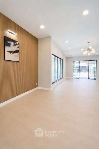 Spacious modern living room with large windows and elegant lighting, perfect for stylish urban living.