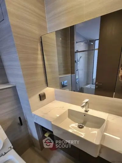 Modern bathroom with sleek sink and large mirror in stylish apartment
