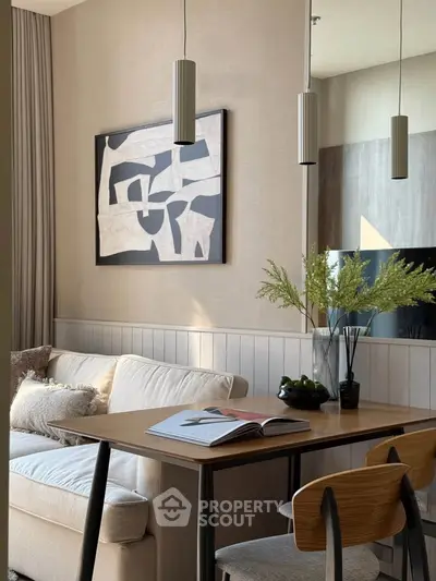 Stylish modern living room with cozy sofa, chic artwork, and elegant dining setup.