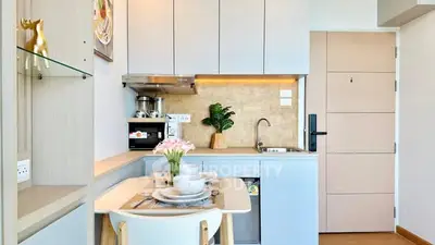Chic compact kitchen with modern appliances and cozy dining area in stylish apartment.