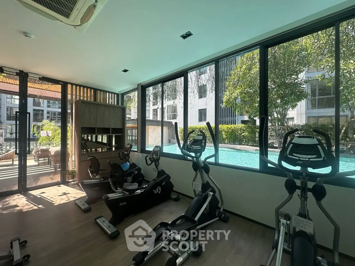Modern gym with pool view in luxury residential complex