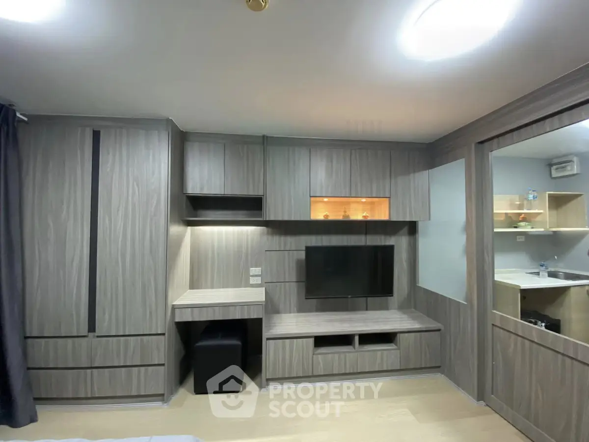 Modern living room with built-in wooden cabinetry and mounted TV