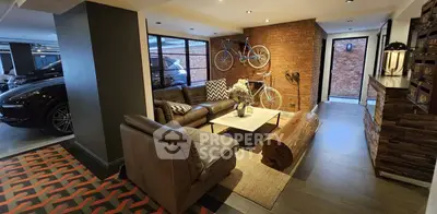 Stylish living room with leather sofas and exposed brick wall in modern home.