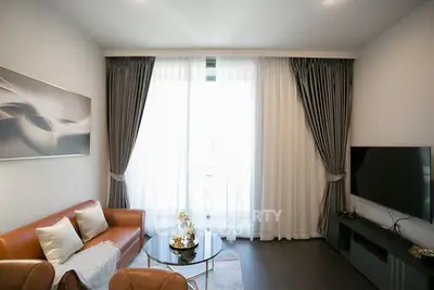 Elegant living room with modern decor, large window, and stylish furniture, perfect for relaxation and entertainment.