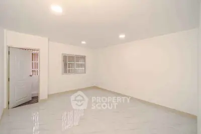 Spacious empty room with tiled flooring and bright lighting, ideal for customization.