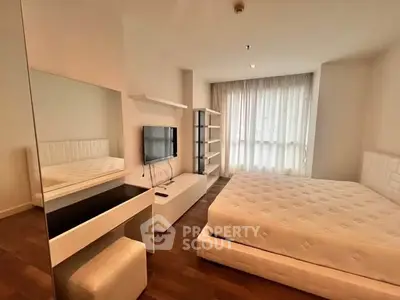 Modern bedroom with sleek furniture and large window for natural light.