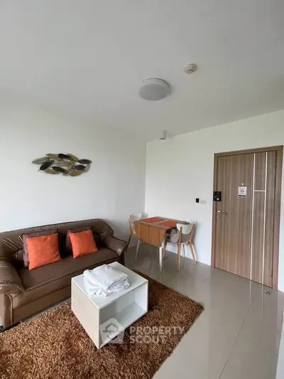 Modern living room with cozy brown sofa, stylish decor, and dining area in a contemporary apartment.