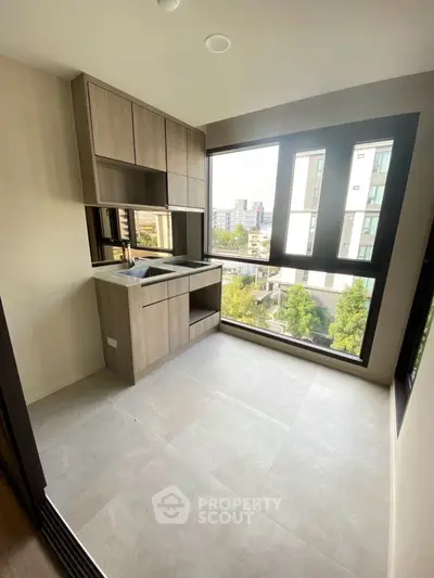 Modern kitchen with large windows and sleek cabinetry offering city views.