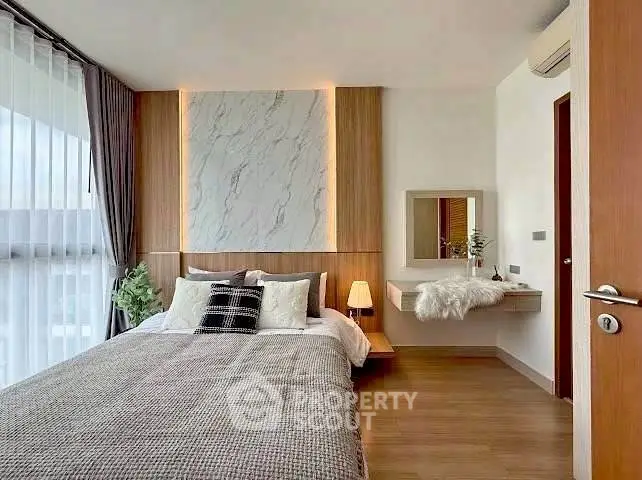 Modern bedroom with stylish decor and natural light, featuring a cozy bed and elegant wall design.