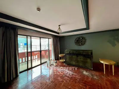 Spacious living room with large windows and balcony access, featuring elegant parquet flooring and stylish decor.